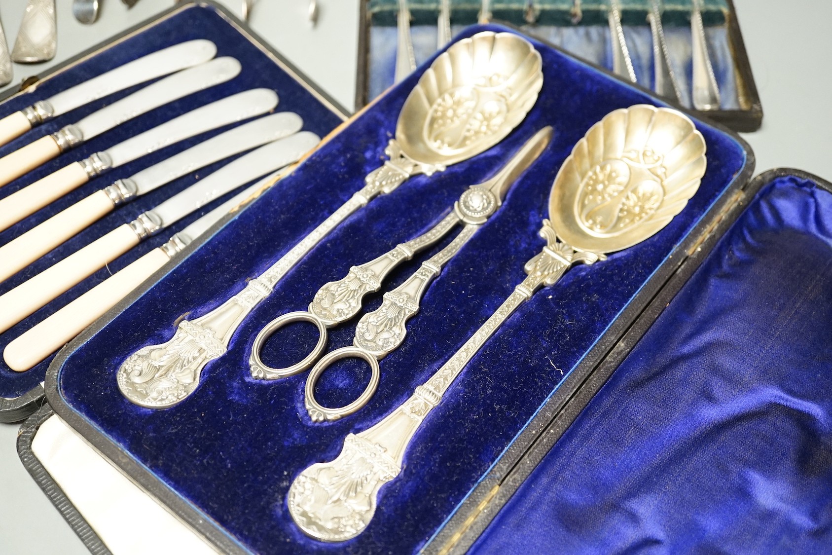 Two pairs of 18th century silver tablespoons including 'berry', a George III silver sifter spoon, pair of sugar tongs and other items including cased plated sets.